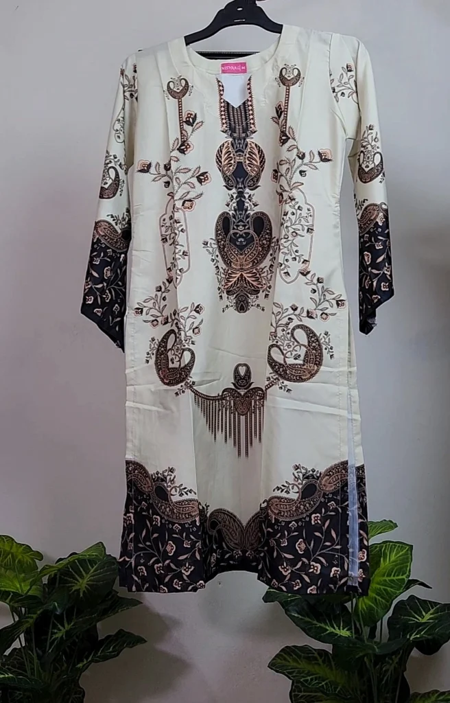 The image shows a traditional long shirt (kurti) with intricate printed designs. Here's a quick description: Fabric Color: Off-white base. Design: Features detailed brown, black, and beige ethnic motifs arranged vertically along the front, with floral and paisley patterns. Sleeves & Hem: The sleeves and lower hem have a contrasting dark (black or deep brown) background with matching floral designs. Neckline: Round with a small slit in the center, bordered with decorative patterns. Would you like help with styling it, identifying fabric type, or writing a product description for a catalog or store?